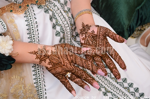 Henna Tattoo on Bride's Hand.Moroccan wedding preparation henna party. Temperate white mehndi. Modern mehendi art.